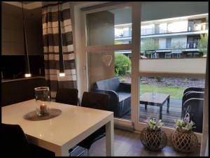 a living room with a table and a sliding glass door at Family Apartment Golden Tulip in Międzyzdroje
