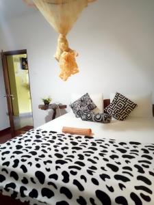 a black and white bed with a teddy bear on the wall at Tunnel Gap Homestay in Ella