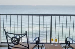 a balcony with a table and two glasses of wine at 1104 The Bermudas - by Stay in Umhlanga in Durban