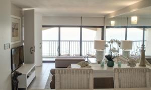 a living room with a table and chairs and a couch at 1104 The Bermudas - by Stay in Umhlanga in Durban