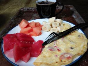 a plate of food with fruit and a cup of coffee at Black Marlin - Kadidiri in Batudaka