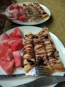dos platos de comida con sandías y un tenedor en Black Marlin - Kadidiri en Batudaka