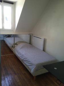 パリにあるSingle room Paris Arc de Triompheの窓付きの客室の小さなベッド1台分です。