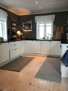 a kitchen with white cabinets and a wooden floor at Jotunheimen Exclusive in Randsverk