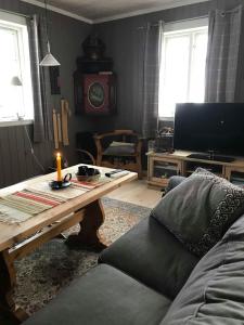 a living room with a couch and a table with a candle at Jotunheimen Exclusive in Randsverk