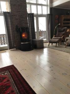 a living room with a wooden floor and a fireplace at Jotunheimen Exclusive in Randsverk