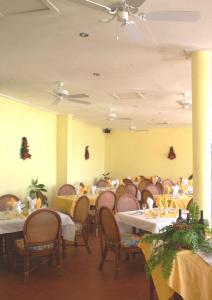 a dining room filled with tables and chairs with yellow walls at Kalinago Beach Resort in Saint Georgeʼs