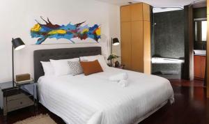 a bedroom with a large bed with a large white bedspread at Saint George - The Townhouse in Melbourne