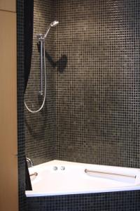 a bathroom with a shower with a sink and a tub at Saint George - The Townhouse in Melbourne