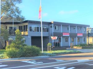 a building with a flag in front of a street at Toukley Motor Inn in Toukley