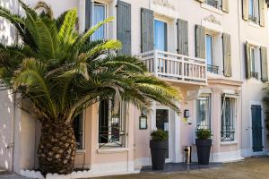 a palm tree in front of a building at Hôtel VAL FLORES LOGIS in Biarritz