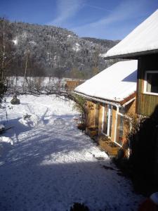 a house covered in snow next to a building at Les Arts Verts in Kruth