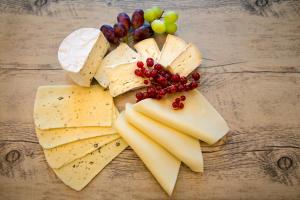 a bunch of cheese and grapes on a wooden table at Hotel NordRaum in Bremen