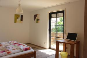 a bedroom with a bed and a desk with a laptop at Gasthof Gruner Baum in Bayreuth