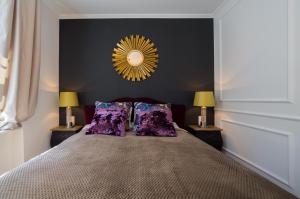グダニスクにあるBasilica Apartment Mariacka Gdanskのベッドルーム1室(紫色の枕と鏡付きのベッド1台付)