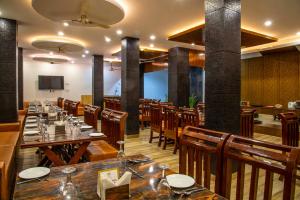 a restaurant with wooden tables and chairs and a screen at Jade Vine Resort in Shogi