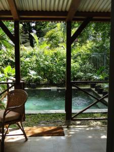 a view of a pool from a porch with a chair at Villa Sirandane in Baie du Tombeau