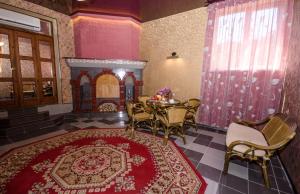 comedor con mesa, sillas y alfombra roja en Guest House K&T, en Sevastopol