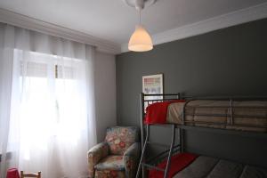 a bedroom with a bunk bed and a chair at Guelbenzu by clabao in Pamplona