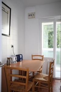 a table and chairs in a kitchen with a window at Guelbenzu by clabao in Pamplona