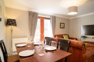een eetkamer met een tafel en een bank bij ALTIDO Elegant 2 bed, 2 bath flat, patio and free parking in Edinburgh