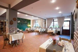 una sala da pranzo con tavoli, sedie e finestre di Casa Vlasin a Poiana Brasov