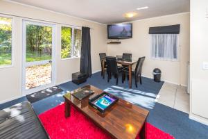 a living room with a table and a dining room at Anndion Lodge Motel & Conference Centre in Whanganui