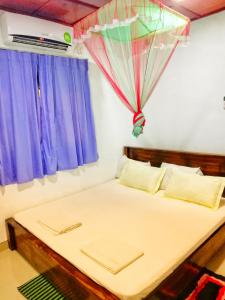 a bedroom with a bed with an umbrella above it at Willwin Park in Anuradhapura