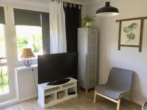 uma sala de estar com uma televisão e uma cadeira em Apartament la mar em Sopot