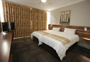 a bedroom with a large bed and a flat screen tv at Hotel Osner in East London