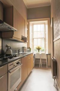 a kitchen with a stove and a sink and a window at ALTIDO Heart of Edinburgh Gem in Edinburgh