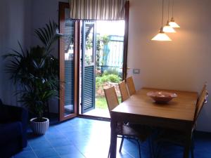 a dining room with a wooden table and a door to a patio at Casa Lorenza in Riomaggiore