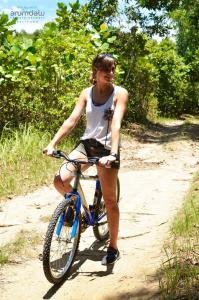 una mujer montando una bicicleta en un camino de tierra en Arumdalu Private Resort en Membalong