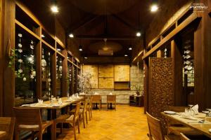 un restaurante con mesas y sillas en una habitación en Arumdalu Private Resort en Membalong