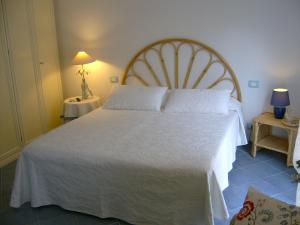 1 dormitorio con 1 cama grande con colcha blanca en Casa Lorenza, en Riomaggiore