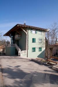 a large white building with a porch on a street at Agritur Scoiattolo in Coredo