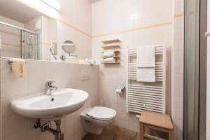 a white bathroom with a sink and a toilet at JUFA Hotel Grundlsee in Grundlsee +41 photos