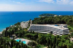 a building on a hill next to the ocean at Lone Hotel by Maistra Collection in Rovinj
