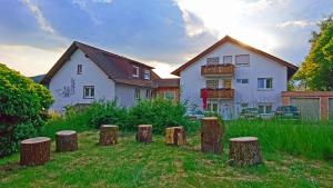 Ein Haus mit einem Haufen Baumstumpfen im Hof in der Unterkunft Pension Weinig in Gersfeld