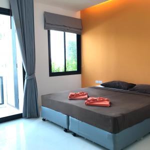 a bedroom with a bed with two red towels on it at V.O.P Suite in Chaweng