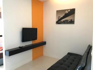 uma sala de estar com um sofá e uma televisão em V.O.P Suite em Chaweng