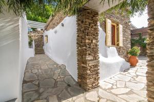 una casa con pareti bianche e un pilastro in pietra di Villa Ghisi ad Arnádhos