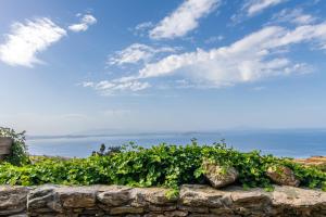a stone wall with the ocean in the background at Villa Ghisi in Arnados