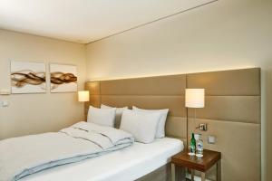Rúm í herbergi á H4 Hotel Solothurn
