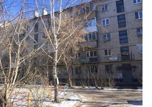 a large brick building with a tree in front of it at Марьин Дом на Луначарского, 171 in Yekaterinburg