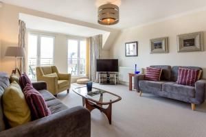 een woonkamer met 2 banken en een tv bij JOIVY Homely Apartment near Leith Walk in Edinburgh