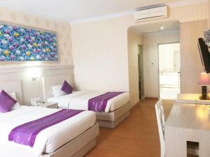 Postel nebo postele na pokoji v ubytování Puri Saron Denpasar Hotel