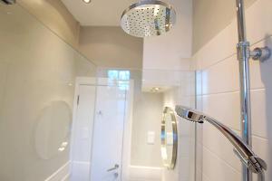 a bathroom with a shower with a glass door at JOIVY Modern City Centre Flat next to Calton Hill in Edinburgh