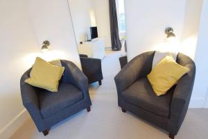 two chairs with yellow pillows in a living room at JOIVY Modern City Centre Flat next to Calton Hill in Edinburgh