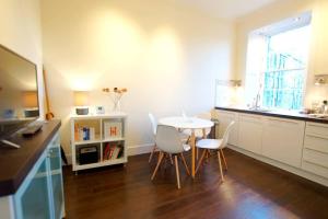 a kitchen with a table and chairs in a room at JOIVY Modern City Centre Flat next to Calton Hill in Edinburgh